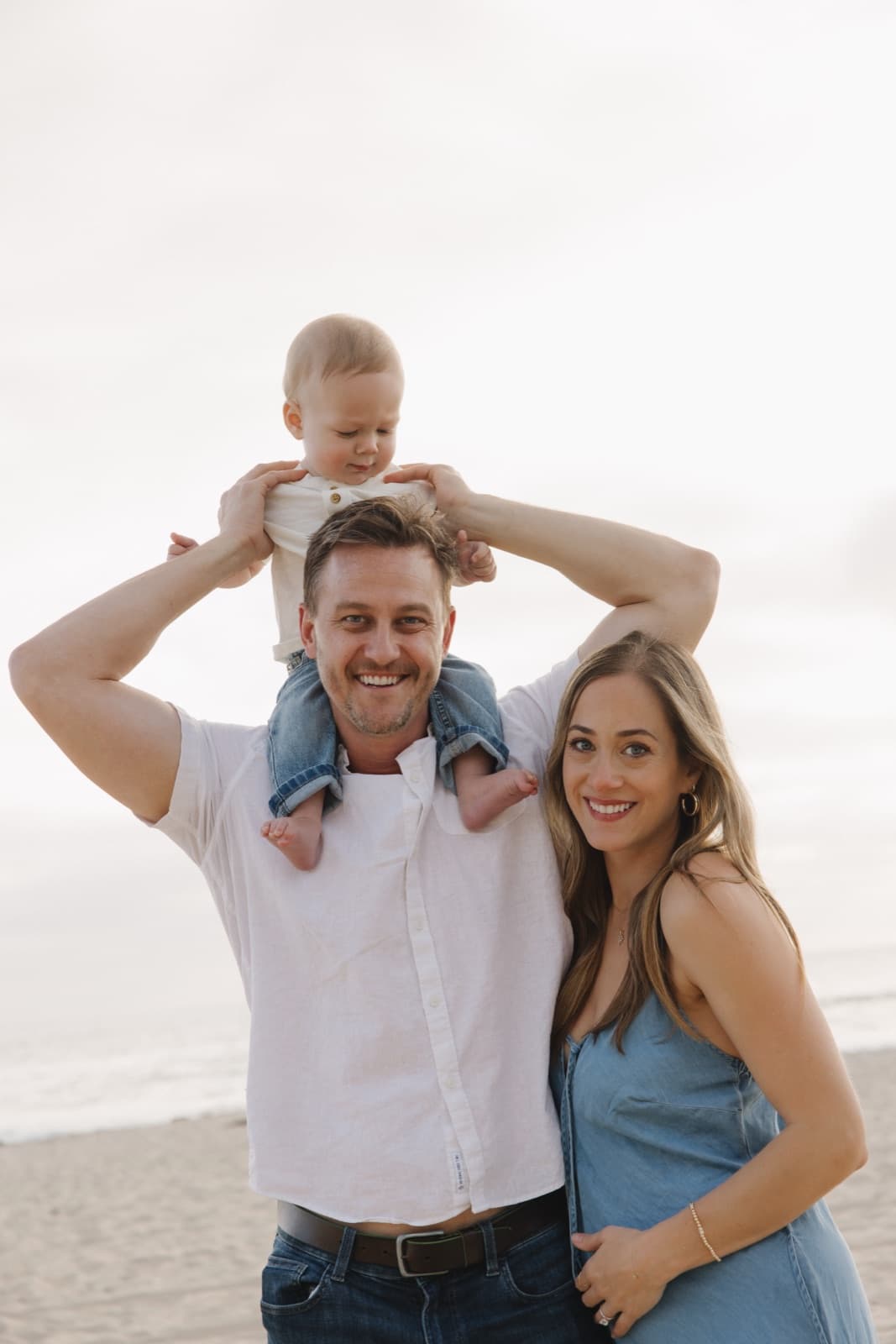 Kyle with his family on the beach, his son Asher on his shoulders